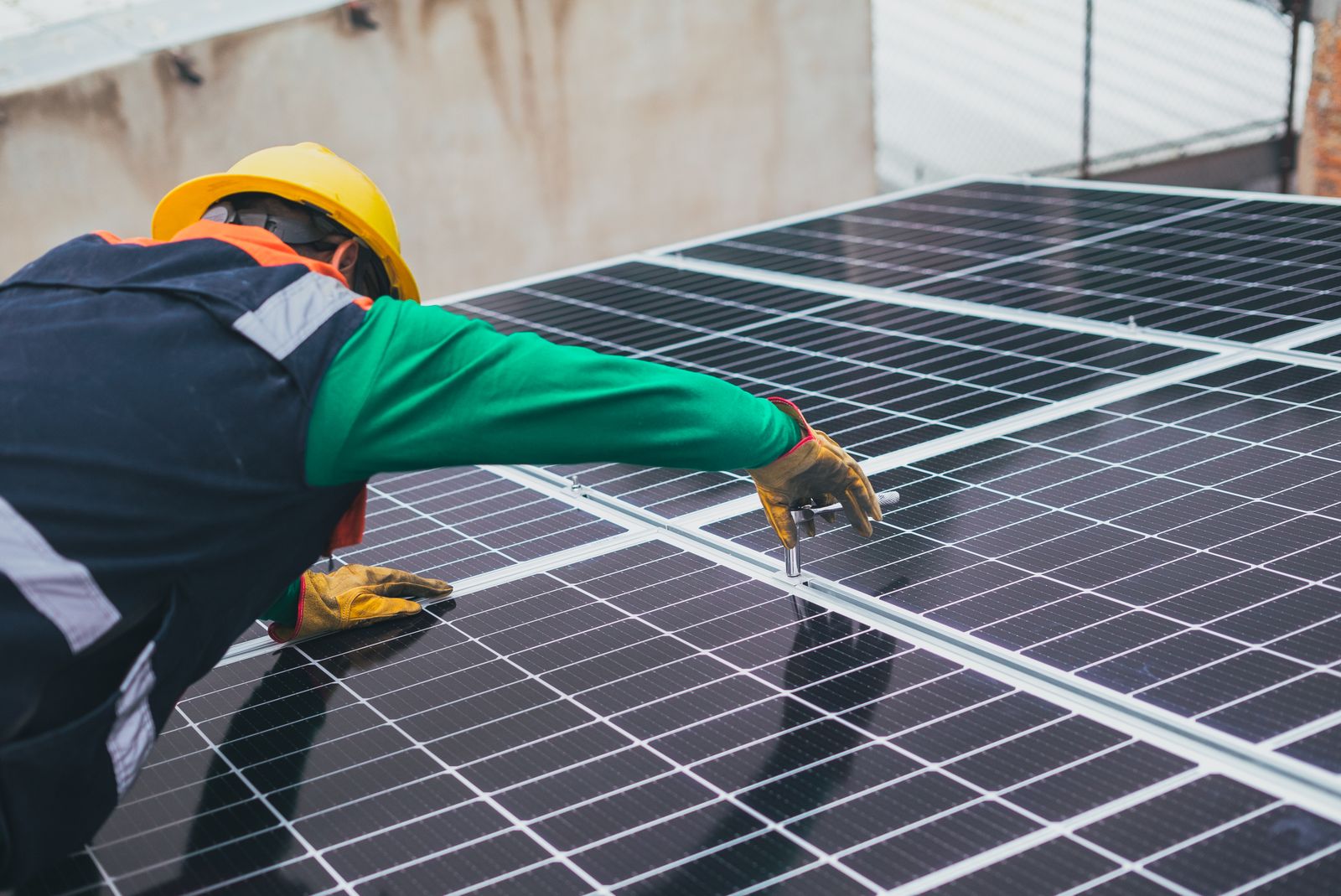 Installateur fixant des panneaux solaires sur un toit